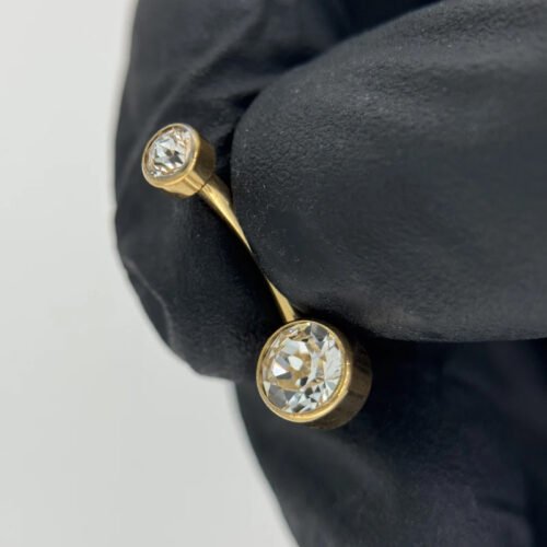 Piercing de ombligo. De titanio con baño de oro 24 Kt y 2 zirconias corte bisel